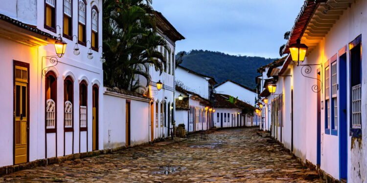 Vista da cidade histórica de Paraty ao entardecer, com a iluminação de suas ruas de paralelepípedos e casas já acesas -  depositphotos.com / fredpinheiro.hotmail.com.br