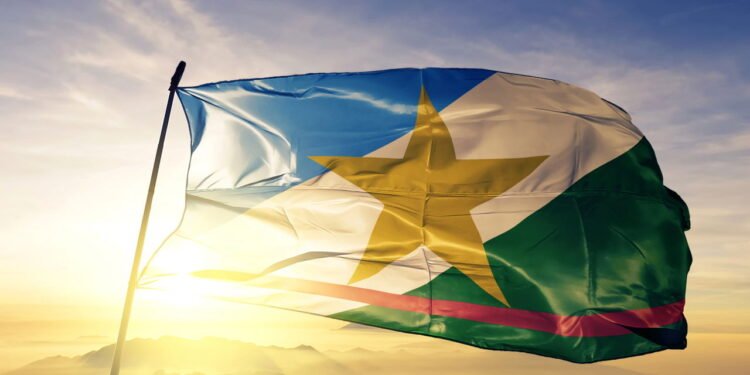 Bandeira do estado de Roraima, Brasil, em tecido ondulando no topo ao nascer do sol com névoa e neblina - depositphotos.com / AleksTaurus