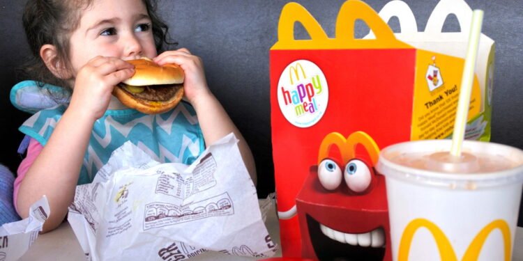 Criança comendo fast-food // Créditos: depositphotos.com / lucidwaters