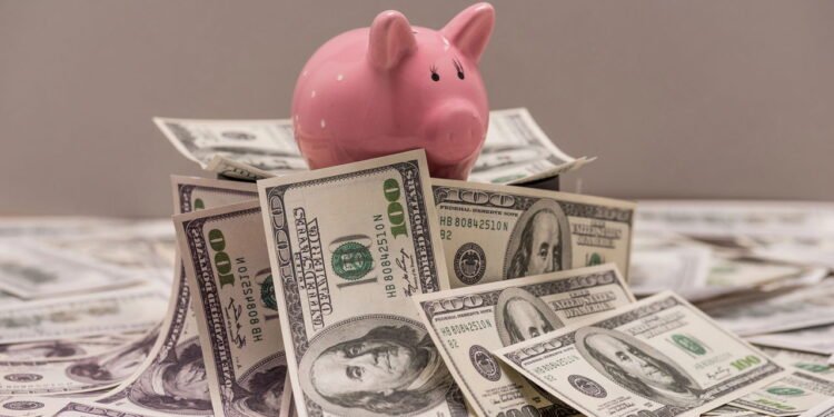 Porquinho e dólar // Créditos: depositphotos.com / SergPoznanskiy