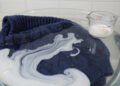 A técnica simples de imersão com 1/3 de xícara de condicionador que relaxa as "escamas" do tecido, desfaz a feltragem da máquina e recupera o tamanho original da sua roupa de lã favorita