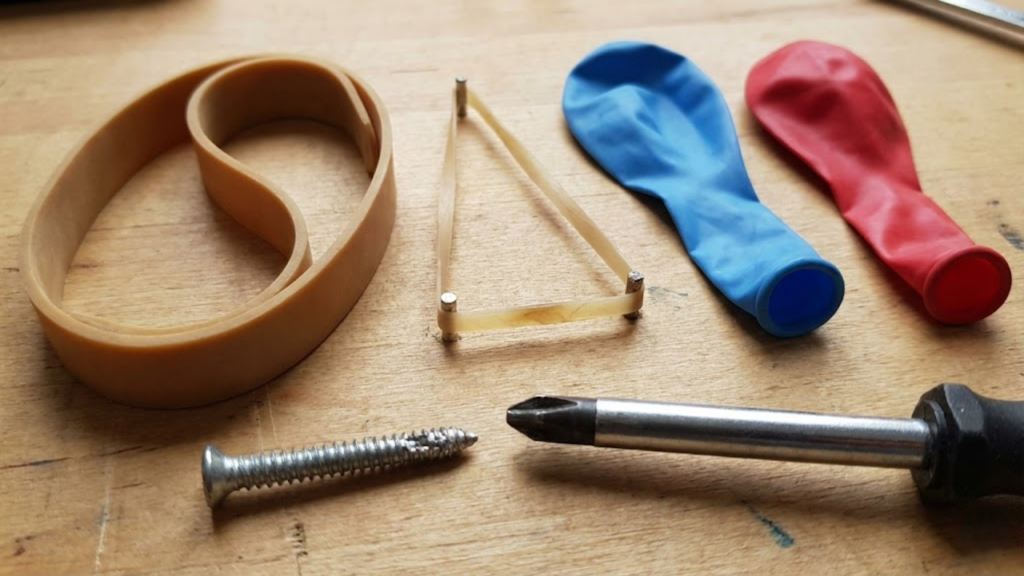 Elástico largo entre a chave e o parafuso espanado aumenta o atrito e facilita a remoção
