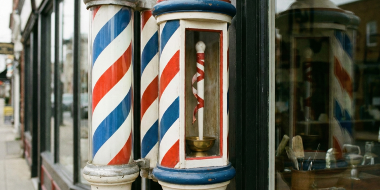 O significado do poste giratório colorido das barbearias