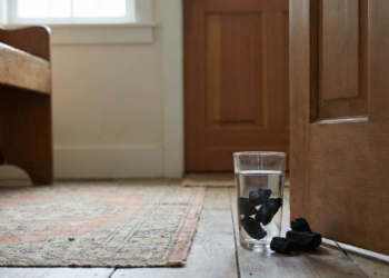 Poucos sabem qual o sentido de colocar carvão em um copo atrás da porta