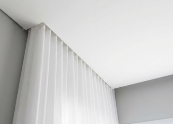 Sala de estar elegante com cortinas longas instaladas próximas ao teto