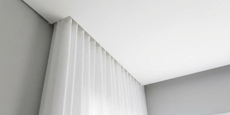 Sala de estar elegante com cortinas longas instaladas próximas ao teto