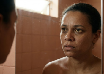 Pessoa preocupada ao espelho notando olhos amarelados e olheiras