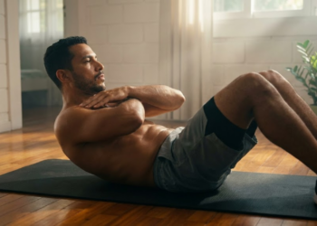 Homem focado fazendo abdominal correto com braços cruzados sob luz matinal
