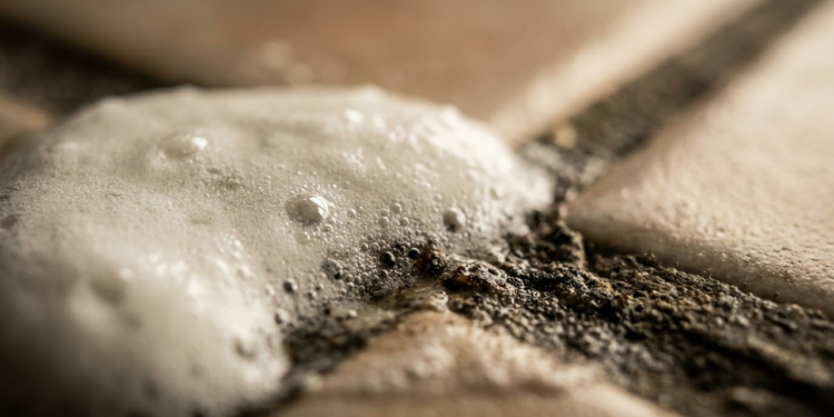 Close macro de mistura efervescente reagindo e soltando a sujeira do rejunte.