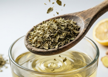 Close macro de folhas secas de orégano caindo em água quente de forma artística.