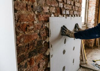 A técnica de colar placas de gesso diretamente na parede velha para criar um acabamento de luxo