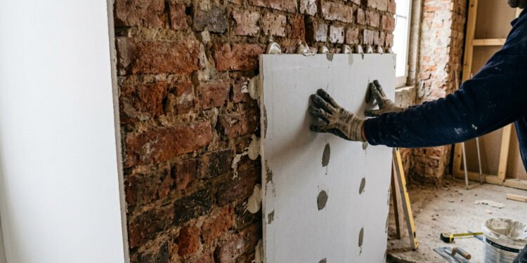 A técnica de colar placas de gesso diretamente na parede velha para criar um acabamento de luxo