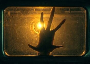 Mão pressionada contra uma janela iluminada por luz dourada em cena da série The Boroughs, da Netflix