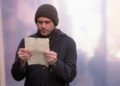 Jim Carrey como Joel Barish lendo uma carta de Clementine em cena de Brilho Eterno de uma Mente sem Lembranças