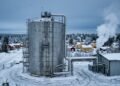 Silo da maior bateria de areia do mundo em paisagem nevada na Finlândia, conectado por tubulações à rede de aquecimento da cidade