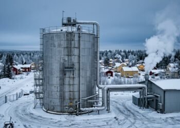 Silo da maior bateria de areia do mundo em paisagem nevada na Finlândia, conectado por tubulações à rede de aquecimento da cidade