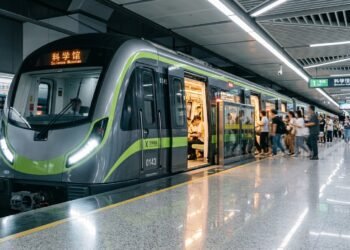 Primeiro trem de metrô de fibra de carbono do mundo parado em estação moderna na China com passageiros embarcando