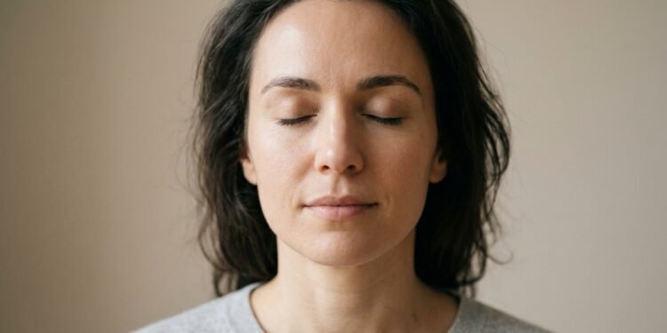 Rosto de uma pessoa com olhos fechados e expressão serena, simbolizando a prática de silêncio e busca por estabilidade emocional.