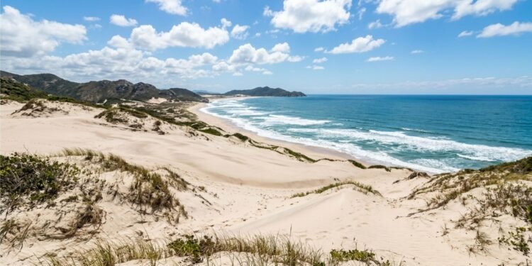A praia do Sul do Brasil com dunas gigantes e sem construções fixas que impressiona por parecer um deserto à beira-mar