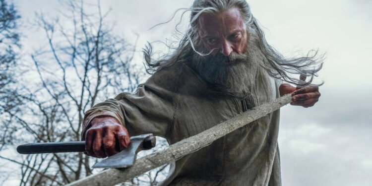 Hugh Jackman caracterizado como Robin Hood, com barba grisalha e expressão sombria, em cena de "A Morte de Robin Hood".