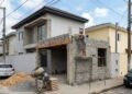 Morador aproveita viagem do vizinho para construir uma garagem encostada na divisa e ultrapassa a altura do muro permitido em 1,5 metro; na volta, o vizinho prejudicado aciona a prefeitura por infração de posturas e exige a demolição da obra irregular
