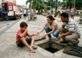 Criança tropeça e cai dentro de uma caixa de escoamento sem tampa e sem sinalização em praça municipal, sofrendo escoriações e fratura no braço; os pais acionam a Prefeitura por responsabilidade civil