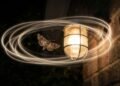 Mariposa em voo ao lado de uma iluminação externa protegida, com a luz direcionada para baixo e o céu escuro ao fundo, representando uma iluminação noturna que reduz a interferência sobre a orientação do inseto.