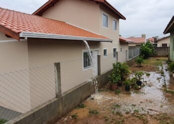 Proprietário termina a obra e deixa o telhado despejar água diretamente no terreno do vizinho; o Código Civil limita o direito de construir mesmo quando tudo permanece dentro do próprio lote