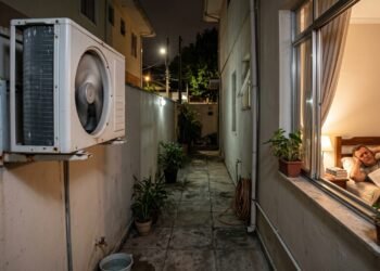 Morador instala condensadora de ar-condicionado no corredor lateral para refrescar a casa; o ruído e a vibração atravessam diariamente a parede do vizinho e atrapalham o sono no quarto ao lado. A disputa pode acabar no Juizado Especial Cível