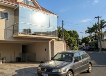 Morador instalou fechamento de varanda com vidros espelhados para bloquear o sol, o reflexo concentrado queima a pintura do carro do vizinho parado na garagem ao lado e a disputa vai parar no Juizado Especial Cível