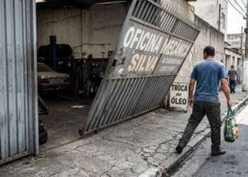 Oficina instala portão basculante automático de alta velocidade que avança 1,20 m sobre a calçada ao abrir sem avisadores sonoros, atingindo pedestres de surpresa; a fiscalização exige a instalação imediata de sinalização