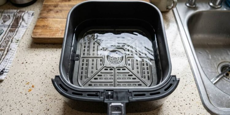 Colocar água no fundo da gaveta da air fryer: para que serve o truque simples que impede a fumaça de gordura queimada na cozinha