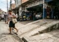 Oficina mecânica instala rampa de alinhamento avançando 80 cm sobre a calçada e força pedestres a desviarem pelo asfalto; fiscalização de posturas autua o estabelecimento em R$ 2.100 e determina a demolição do trecho irregular