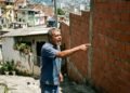 Morador aproveita viagem do vizinho para construir uma garagem encostada na divisa e ultrapassa a altura do muro permitido em 1,5 metro; na volta, o vizinho prejudicado aciona a prefeitura por infração de posturas e exige a demolição da obra irregular