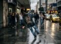 Comerciante substitui o piso tátil e antiderrapante da calçada por porcelanato polido de alta rigidez, causando quedas frequentes de pedestres em dias de chuva; a prefeitura autua o estabelecimento por descumprimento das normas municipais de acessibilidade
