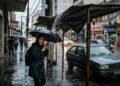 Proprietário constrói puxadinho para proteger a garagem e deixa a borda do telhado avançando sobre a calçada a apenas 2,10 m de altura, fazendo a enxurrada de chuva cair como uma cascata na cabeça de quem passa; o município notifica o morador para recuar a cobertura e instalar sistema de calhas e condutores