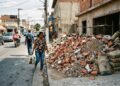 Proprietário descarta 4 toneladas de restos de demolição direto no passeio público em vez de contratar caçamba credenciada, forçando pedestres a transitar pela via dos carros; a fiscalização urbana aplica o Código de Posturas e exige a remoção imediata do entulho