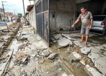 Companhia municipal de saneamento realiza reparos na tubulação da rua, deixa a junta de vedação mal encaixada e o vazamento de água pluvial estoura o piso da garagem da residência em frente