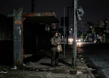 Trabalhadores do bairro fazem sucessivos protocolos na Prefeitura exigindo a troca das lâmpadas de três postes queimados ao lado do ponto final, os pedidos são ignorados por 8 meses e uma usuária é assaltada no escuro; a situação vira Ação Civil Pública do Ministério Público contra o município