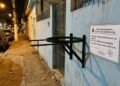 Morador fixa suporte metálico de lixeira com hastes pontiagudas projetadas para fora da linha do lote na altura da cabeça dos pedestres, provocando acidentes com pessoas que caminham à noite; a prefeitura autua o responsável por colocação de obstáculo perigoso em área pública