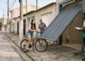 Morador instala portão basculante que avança 80 centímetros sobre a calçada durante a abertura e quase atinge uma ciclista; prefeitura determina adaptação do equipamento e aplica multa por risco à circulação de pedestres