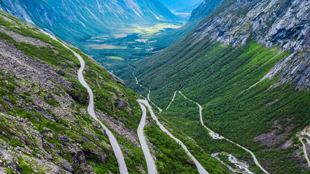 Com onze curvas fechadas esculpidas na montanha e inclinação de 9%, a estrada de Trollstigen na Noruega desafia motoristas sob neblina