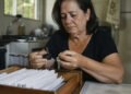 Viúva diante dos documentos que adiou por dois anos