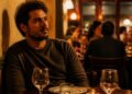 Homem sentado de costas para a parede no restaurante