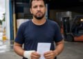 Trabalhador com a mão enfaixada segura a carta de demissão