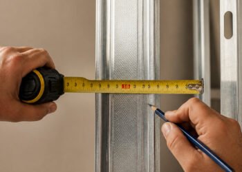 Marca vermelha da trena sobre o montante de drywall