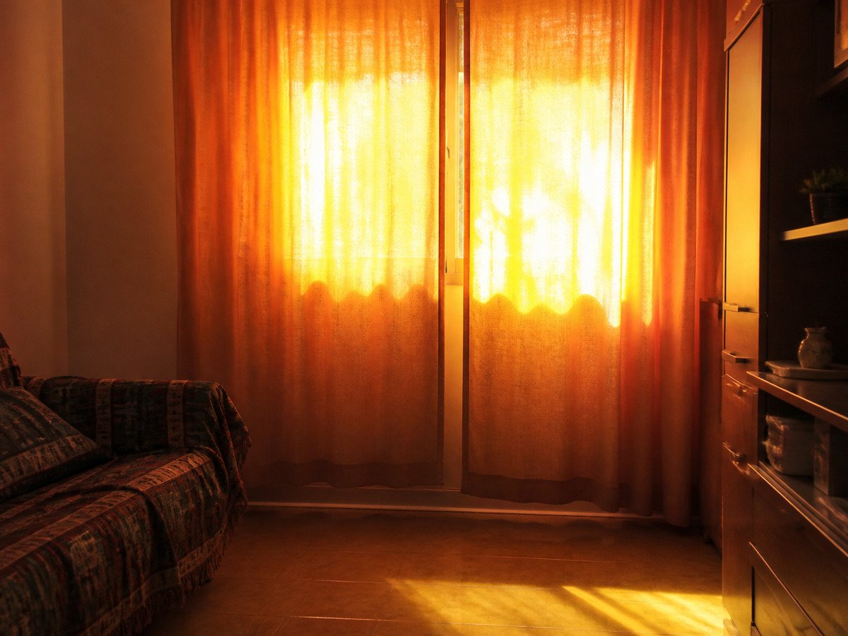 Cortina fechada por dentro brilhando com o sol