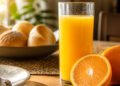 Copo de suco de laranja e a fruta inteira ao lado