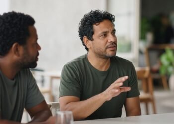 Duas pessoas conversam num café e uma delas desvia o olhar enquanto pensa