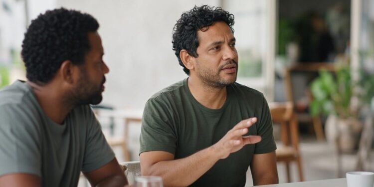 Duas pessoas conversam num café e uma delas desvia o olhar enquanto pensa